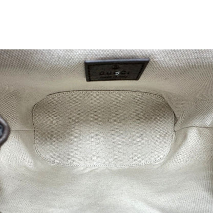 Interno di uno zaino Gucci in canvas beige GG con finiture in pelle marroni e parti metalliche dorate. Iconica striscia Web in verde/rosso sulla patta, impreziosita da un manico in catena amovibile e cinghie in pelle regolabili. Completo di dustbag.