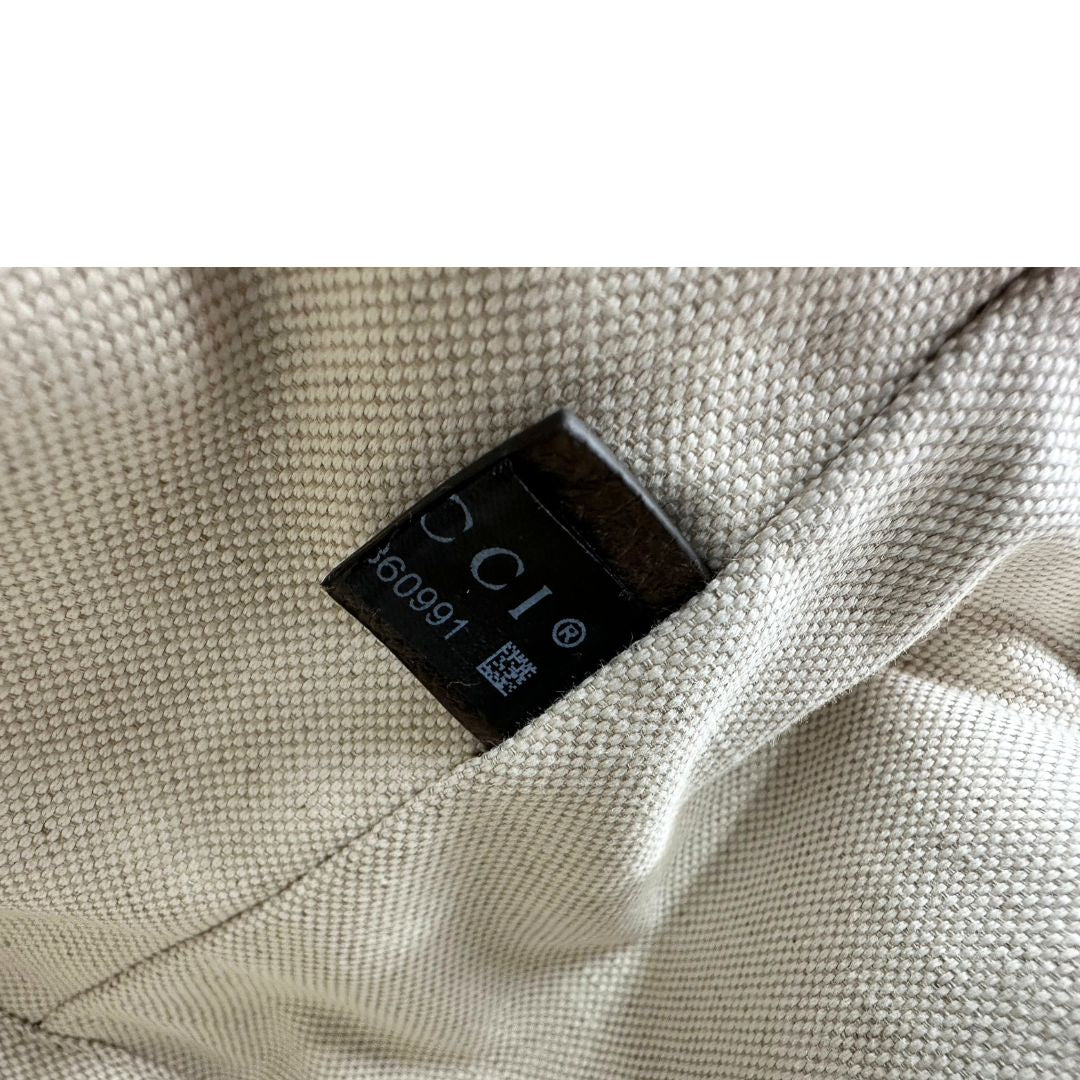 Codice di uno zaino Gucci in canvas beige GG con finiture in pelle marroni e parti metalliche dorate. Iconica striscia Web in verde/rosso sulla patta, impreziosita da un manico in catena amovibile e cinghie in pelle regolabili. Completo di dustbag.
