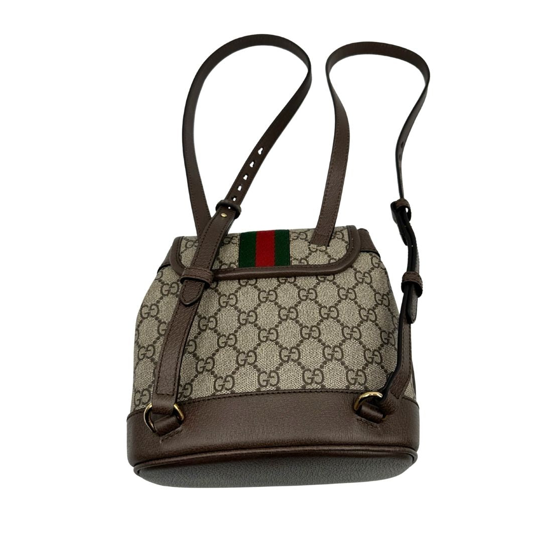 Retro di uno zaino Gucci in canvas beige GG con finiture in pelle marroni e parti metalliche dorate. Iconica striscia Web in verde/rosso sulla patta, impreziosita da un manico in catena amovibile e cinghie in pelle regolabili. Completo di dustbag.