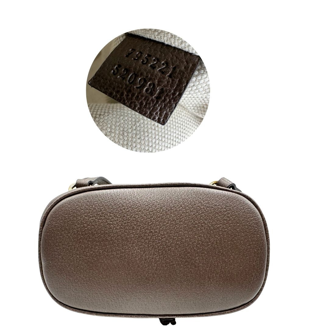 Base e codice di uno zaino Gucci in canvas beige GG con finiture in pelle marroni e parti metalliche dorate. Iconica striscia Web in verde/rosso sulla patta, impreziosita da un manico in catena amovibile e cinghie in pelle regolabili. Completo di dustbag.