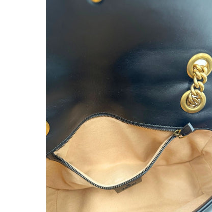 Interno di una Borsa Gucci Marmont in pelle matelassé nera con tracolla scorrevole in catena e spallaccio in pelle, rifinita con parti metalliche dorate; indossabile a spalla oppure a tracolla. Completa di dustbag. Originale, usata, di lusso, in ottime condizioni.