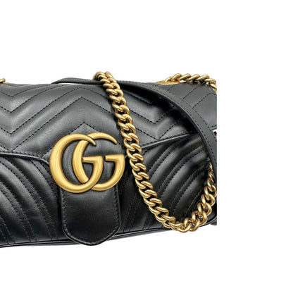 Borsa Gucci Marmont in pelle matelassé nera con tracolla scorrevole in catena e spallaccio in pelle, rifinita con parti metalliche dorate; indossabile a spalla oppure a tracolla. Completa di dustbag. Originale, usata, di lusso, in ottime condizioni.