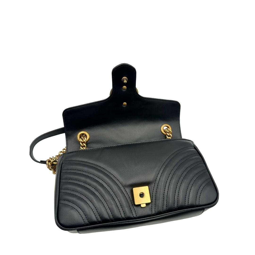 Borsa Gucci Marmont in pelle matelassé nera con tracolla scorrevole in catena e spallaccio in pelle, rifinita con parti metalliche dorate; indossabile a spalla oppure a tracolla. Completa di dustbag. Originale, usata, di lusso, in ottime condizioni.
