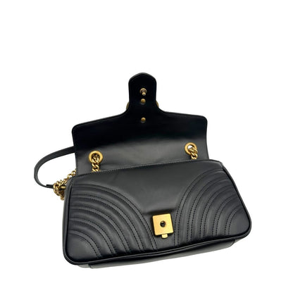 Borsa Gucci Marmont in pelle matelassé nera con tracolla scorrevole in catena e spallaccio in pelle, rifinita con parti metalliche dorate; indossabile a spalla oppure a tracolla. Completa di dustbag. Originale, usata, di lusso, in ottime condizioni.