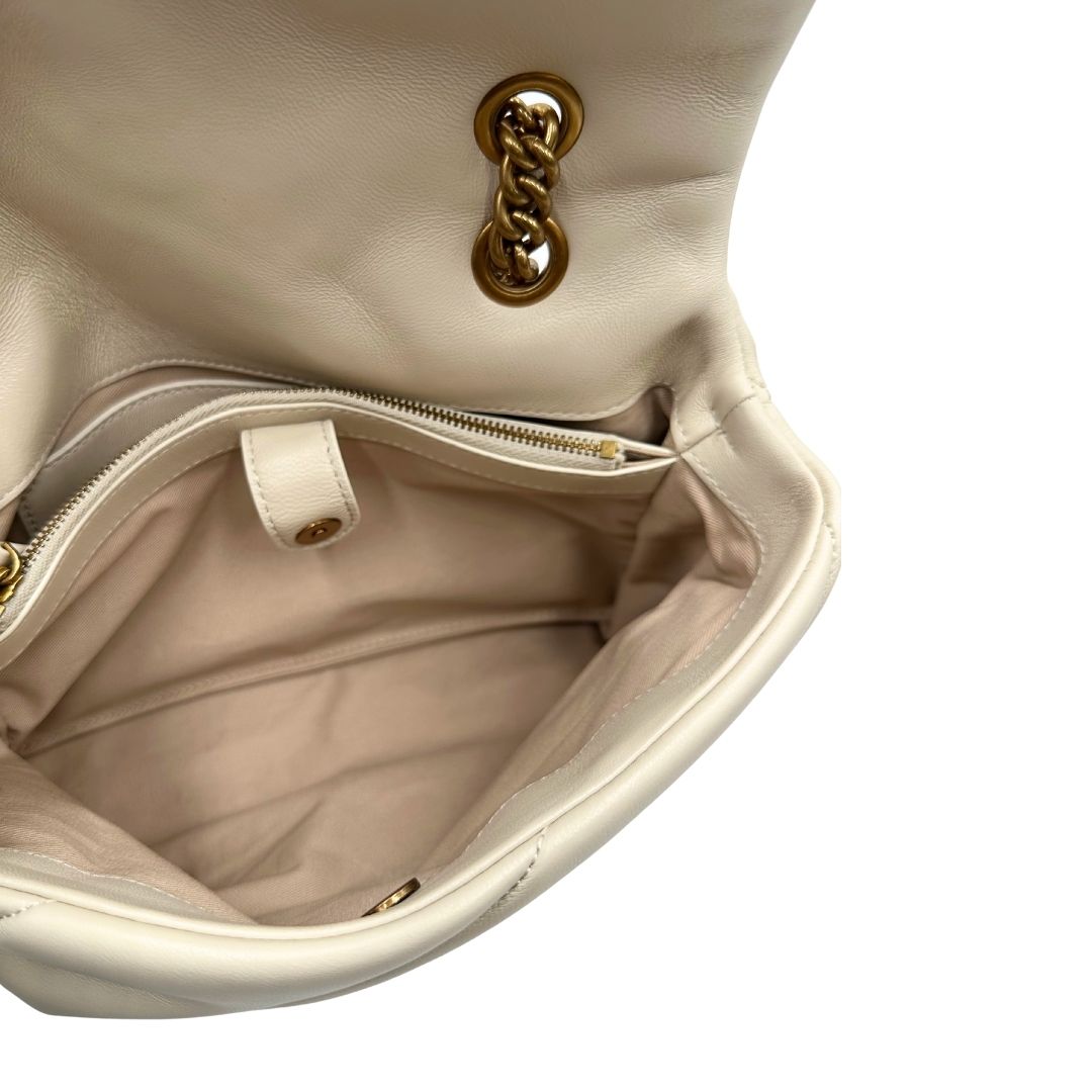 Interno di una borsa Pinko in pelle trapuntata bianco latte con parti metalliche dorate; munita di una tracolla in catena scorrevole con spallaccio in pelle. Completa di dustbag e cartellino. Indossabile a spalla o a tracolla.