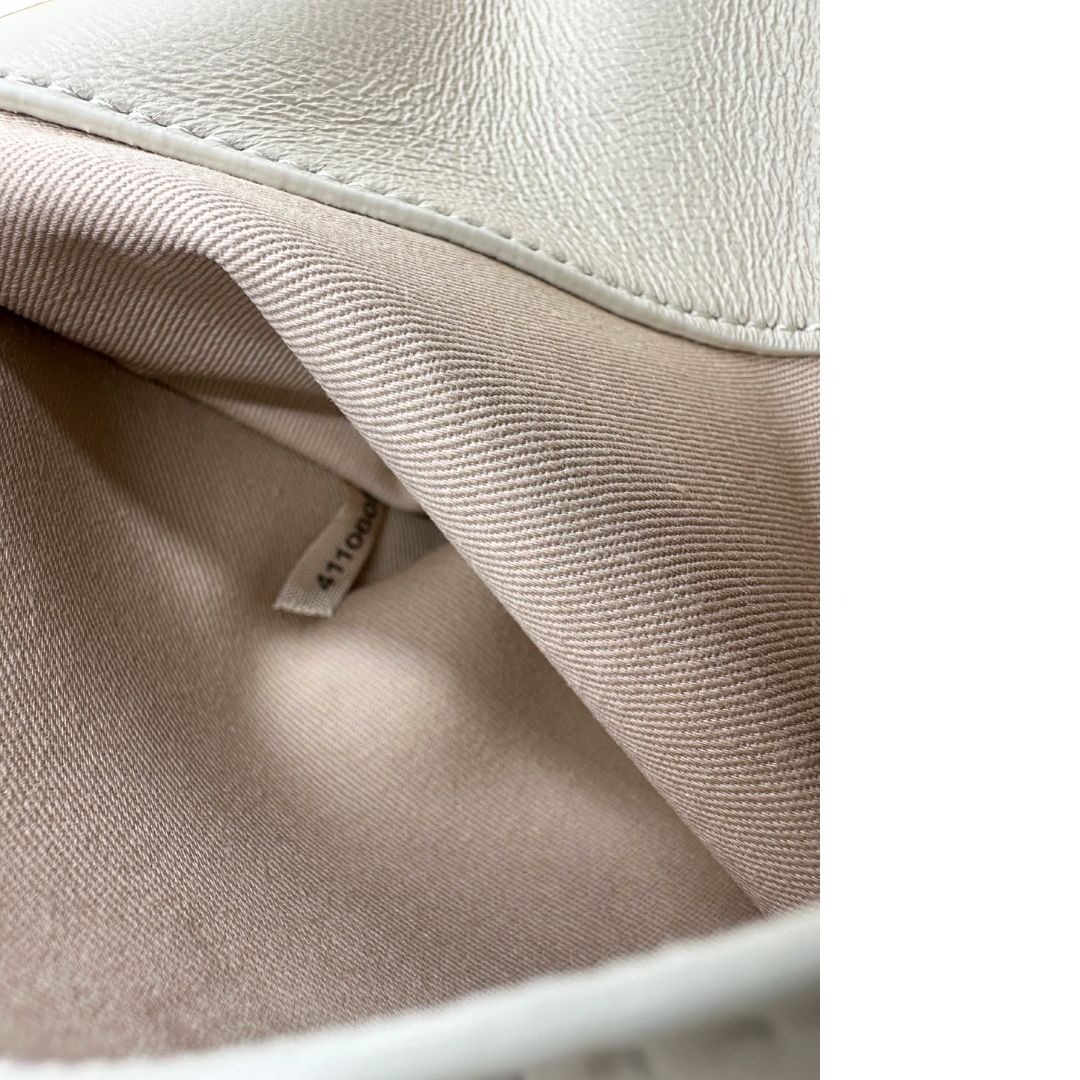 Codice di una borsa Pinko in pelle trapuntata bianco latte con parti metalliche dorate; munita di una tracolla in catena scorrevole con spallaccio in pelle. Completa di dustbag e cartellino. Indossabile a spalla o a tracolla.