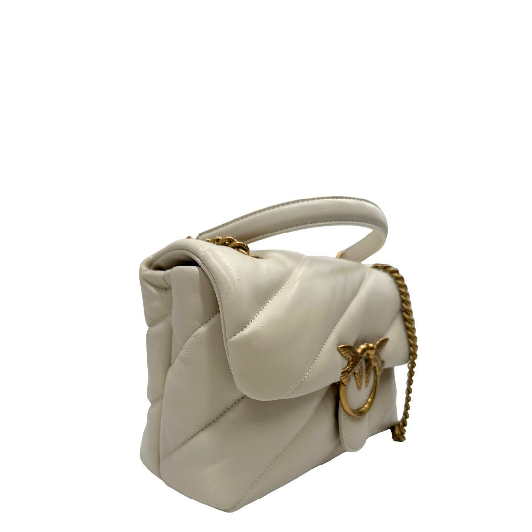 Laterale sinistro di una borsa Pinko in pelle trapuntata bianco latte con parti metalliche dorate; munita di una tracolla in catena scorrevole con spallaccio in pelle. Completa di dustbag e cartellino. Indossabile a spalla o a tracolla.