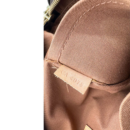 Codice di una Borsa Louis Vuitton in canvas marrone monogram con finiture in vacchetta naturale e parti metalliche dorate; munita di due manici e una tracolla in tessuto regolabile. Completa di dustbag. Originale, usata, di lusso, in ottime condizioni.