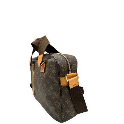 Lato sinistro di una Borsa Louis Vuitton in canvas marrone monogram con finiture in vacchetta naturale e parti metalliche dorate; munita di due manici e una tracolla in tessuto regolabile. Completa di dustbag. Originale, usata, di lusso, in ottime condizioni.