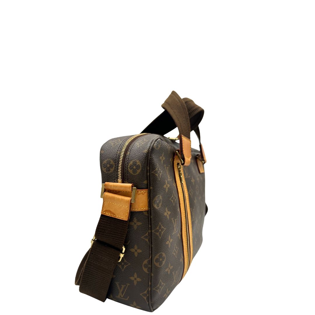 Lato destro di una Borsa Louis Vuitton in canvas marrone monogram con finiture in vacchetta naturale e parti metalliche dorate; munita di due manici e una tracolla in tessuto regolabile. Completa di dustbag. Originale, usata, di lusso, in ottime condizioni.