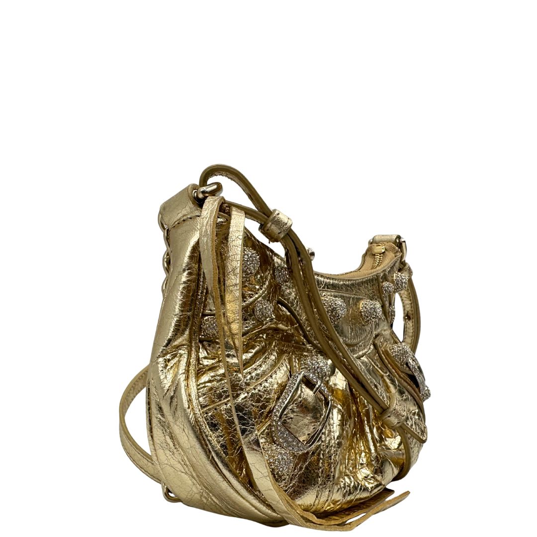 lato Borsa Balenciaga in pelle dorata con parti metalliche dorate, impreziosita da borchie con cristalli incastonati; munita di un manico in catena e una tracolla regolabile. Completa di dustbag, di lusso, originale, ottime condizioni. 