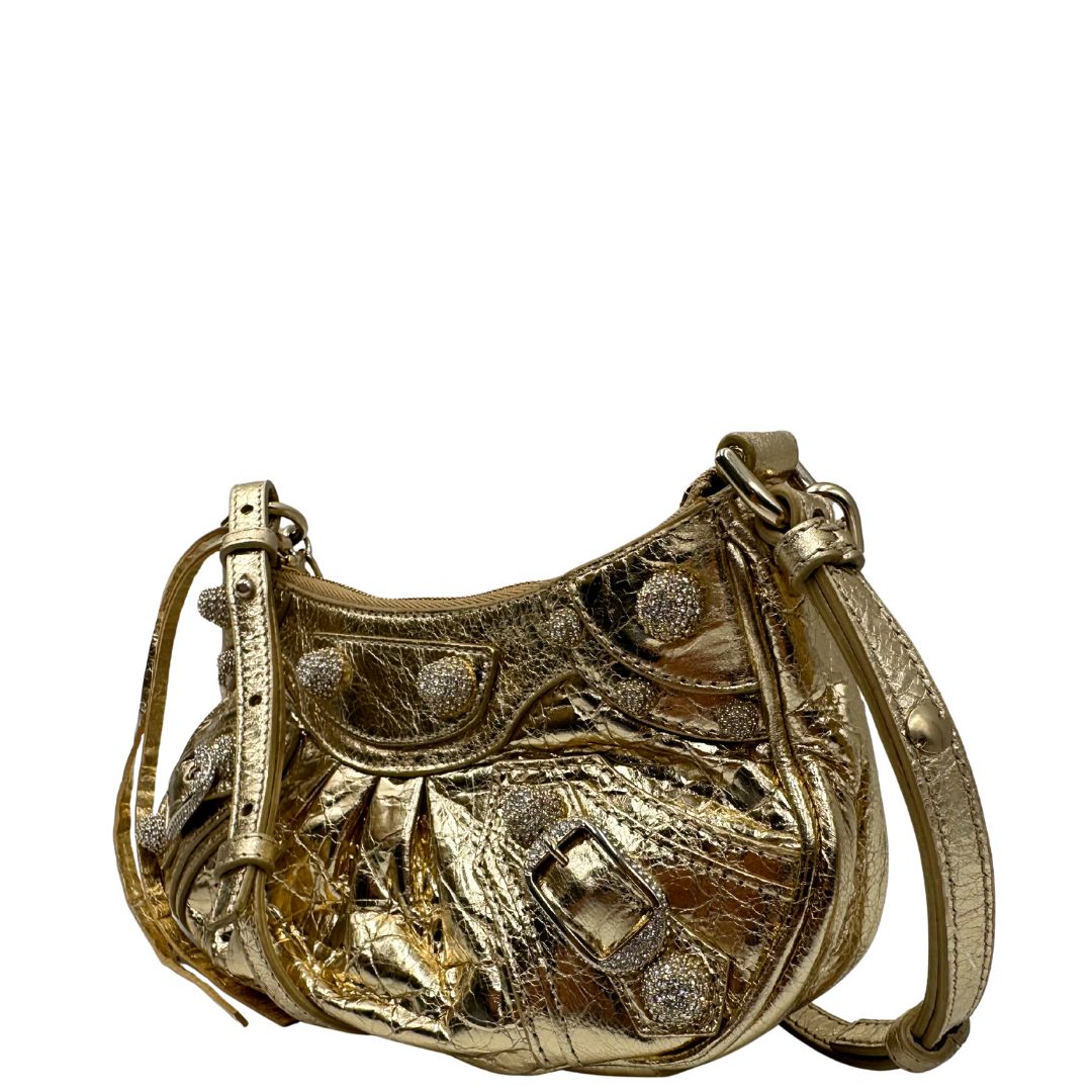 lato Borsa Balenciaga in pelle dorata con parti metalliche dorate, impreziosita da borchie con cristalli incastonati; munita di un manico in catena e una tracolla regolabile. Completa di dustbag, di lusso, originale, ottime condizioni. 
