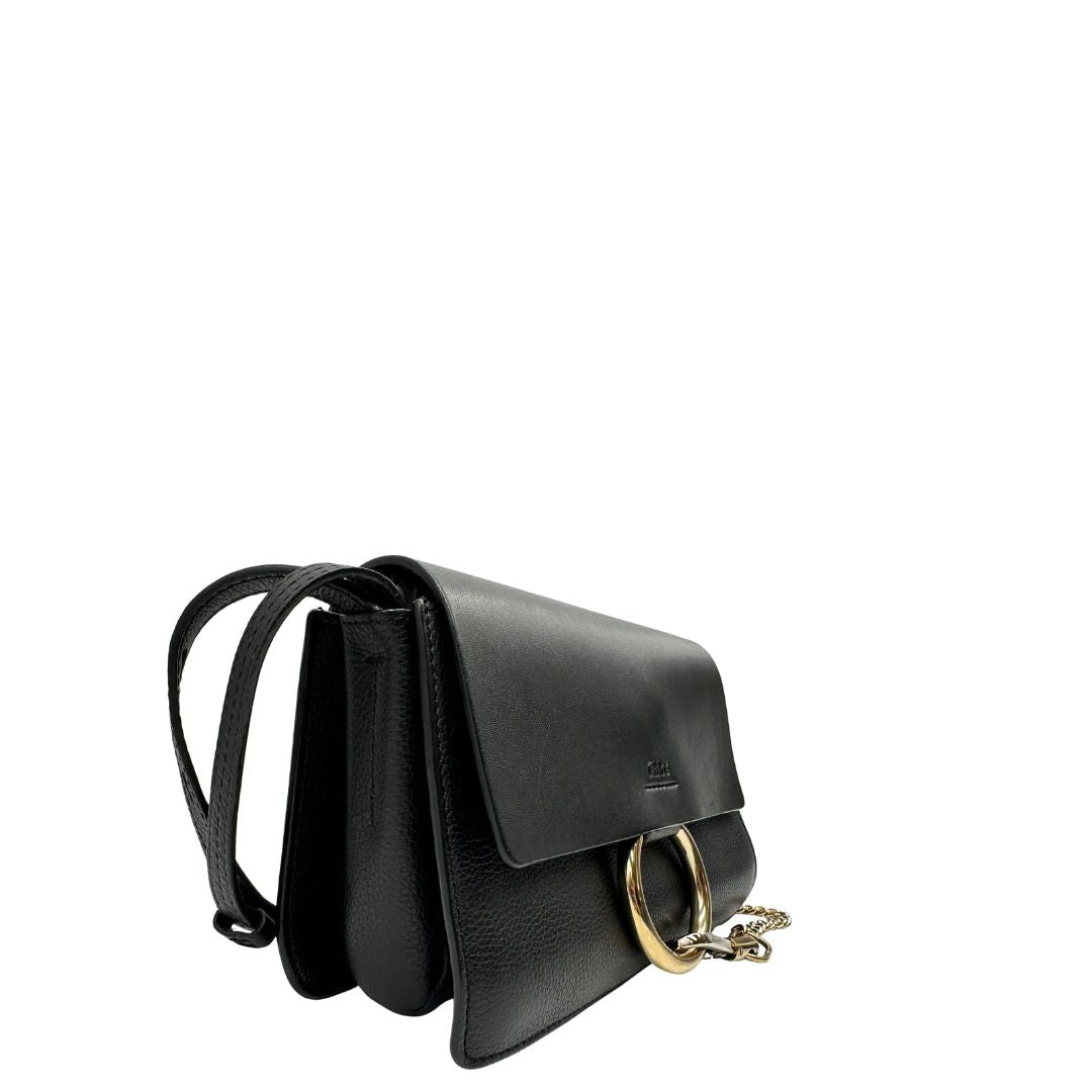 Lato destro di una Borsa Chloé Faye in pelle martellata nera con parti metalliche dorate, munita di una tracolla regolabile. Impreziosita di una chiusura principale con gancio con l'iconico anello sul davanti, collegato a una piccola catena a moschettone. Indossabile a tracolla .Originale, usata, di lusso, in ottime condizioni.