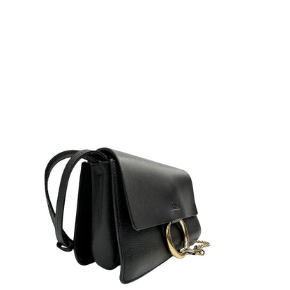Lato destro di una Borsa Chloé Faye in pelle martellata nera con parti metalliche dorate, munita di una tracolla regolabile. Impreziosita di una chiusura principale con gancio con l'iconico anello sul davanti, collegato a una piccola catena a moschettone. Indossabile a tracolla .Originale, usata, di lusso, in ottime condizioni.