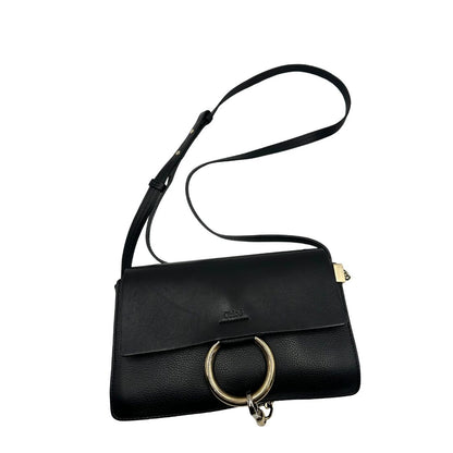 Borsa Chloé Faye in pelle martellata nera con parti metalliche dorate, munita di una tracolla regolabile. Impreziosita di una chiusura principale con gancio con l'iconico anello sul davanti, collegato a una piccola catena a moschettone. Indossabile a tracolla .Originale, usata, di lusso, in ottime condizioni.
