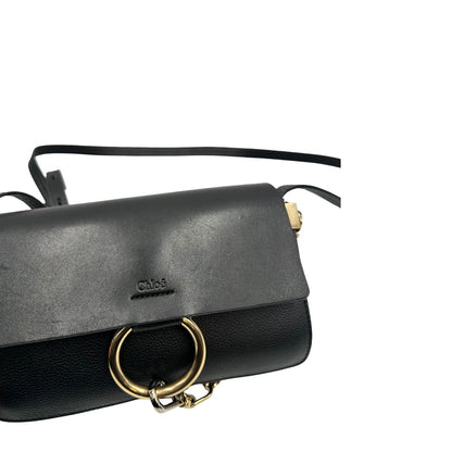Borsa Chloé Faye in pelle martellata nera con parti metalliche dorate, munita di una tracolla regolabile. Impreziosita di una chiusura principale con gancio con l'iconico anello sul davanti, collegato a una piccola catena a moschettone. Indossabile a tracolla .Originale, usata, di lusso, in ottime condizioni.