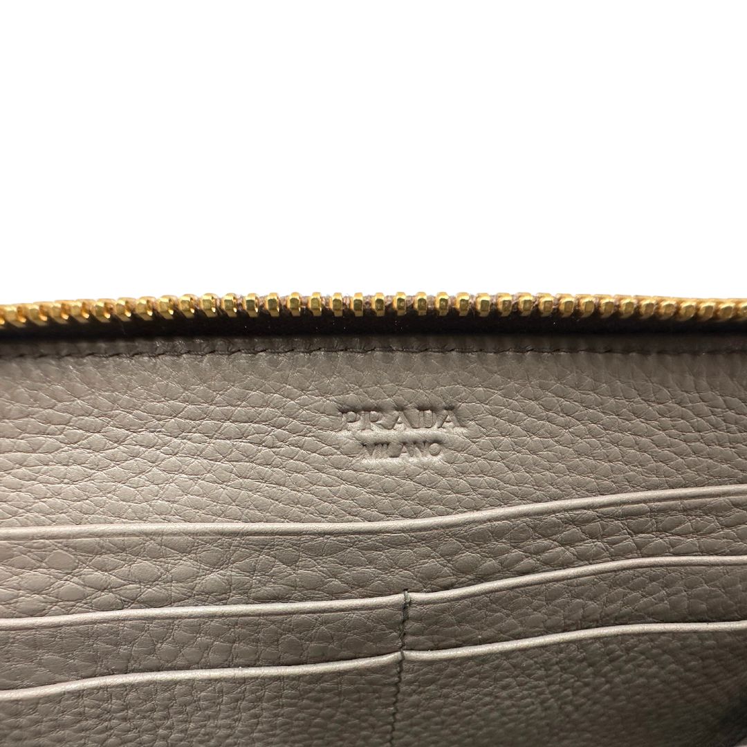 Interno di un Portafoglio Prada in pelle martellata color grigio tortora, con parti metalliche dorate. Originale, usato, di lusso, in ottime condizioni.