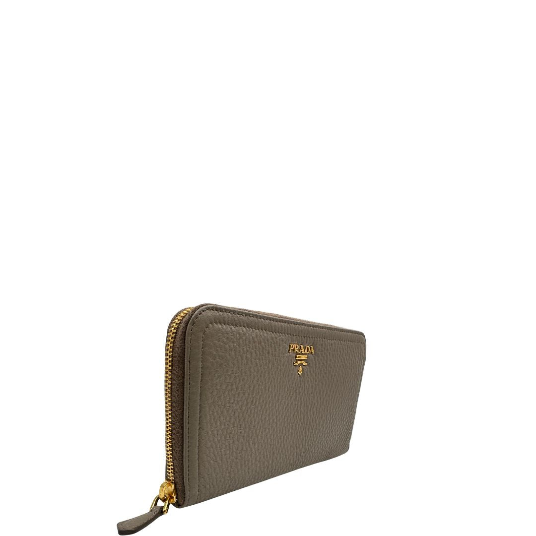 Lato destro di un Portafoglio Prada in pelle martellata color grigio tortora, con parti metalliche dorate. Originale, usato, di lusso, in ottime condizioni.