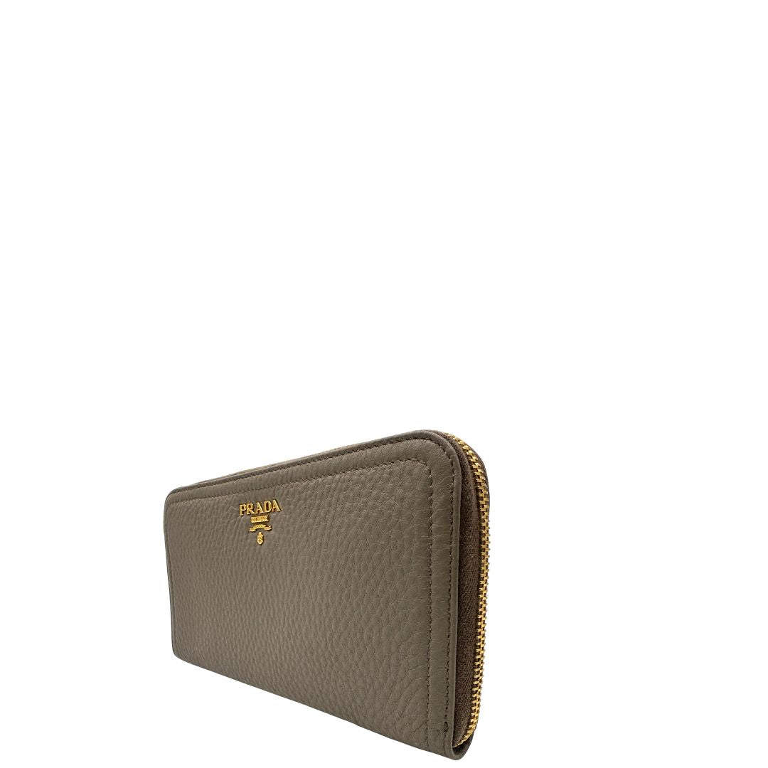 Lato sinistro di un Portafoglio Prada in pelle martellata color grigio tortora, con parti metalliche dorate. Originale, usato, di lusso, in ottime condizioni.
