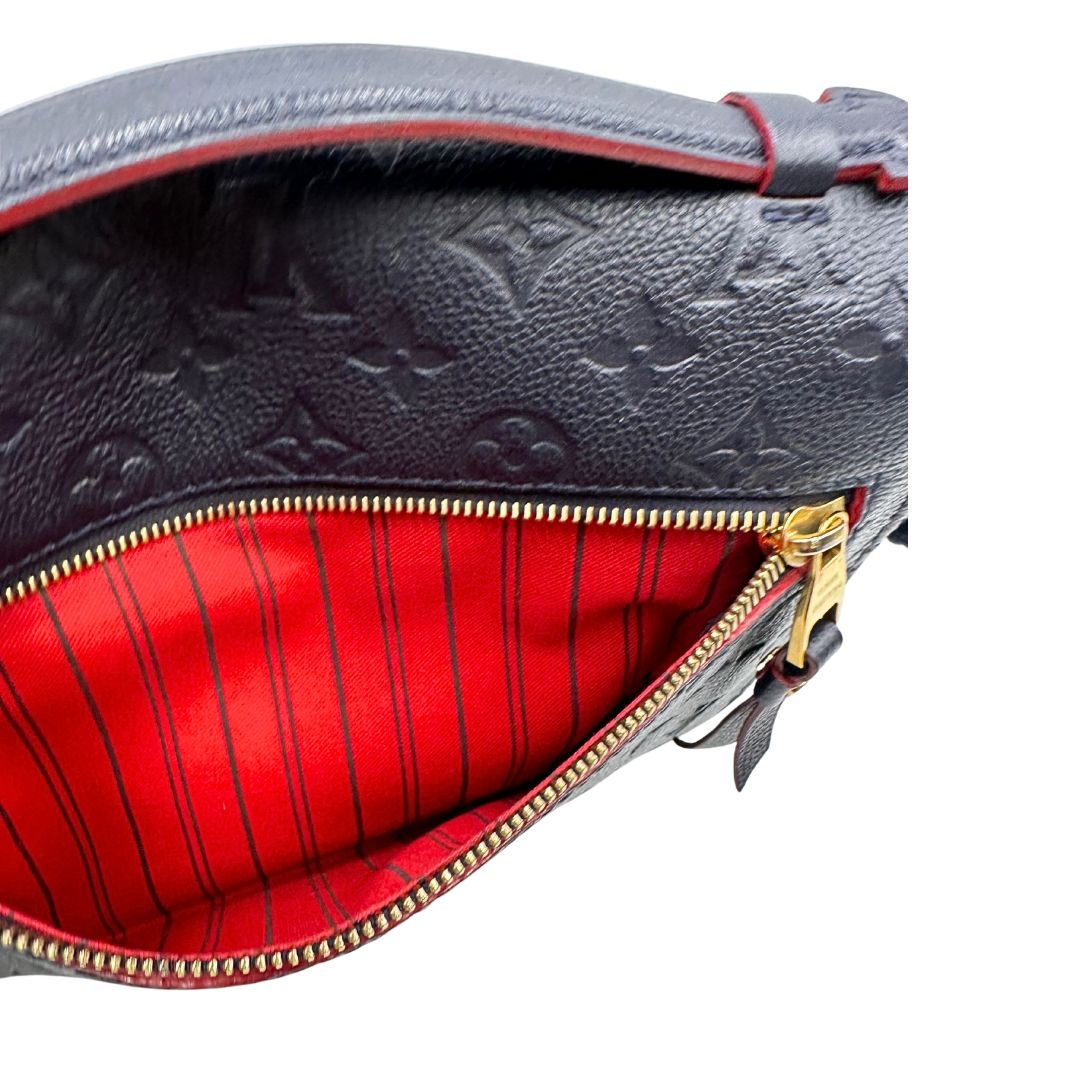 Tasca esterna di una Borsa Louis Vuitton Métis in pelle monogram empreinte blu notte con parti metalliche dorate. Munita di un manico e tracolla regolabile con fibbia, e amovibile. Completa di corredo. Originale, usata, di lusso, in ottime condizioni.