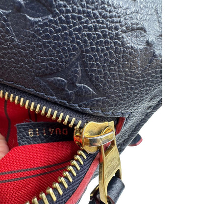 Codice di una Borsa Louis Vuitton Métis in pelle monogram empreinte blu notte con parti metalliche dorate. Munita di un manico e tracolla regolabile con fibbia, e amovibile. Completa di corredo. Originale, usata, di lusso, in ottime condizioni.