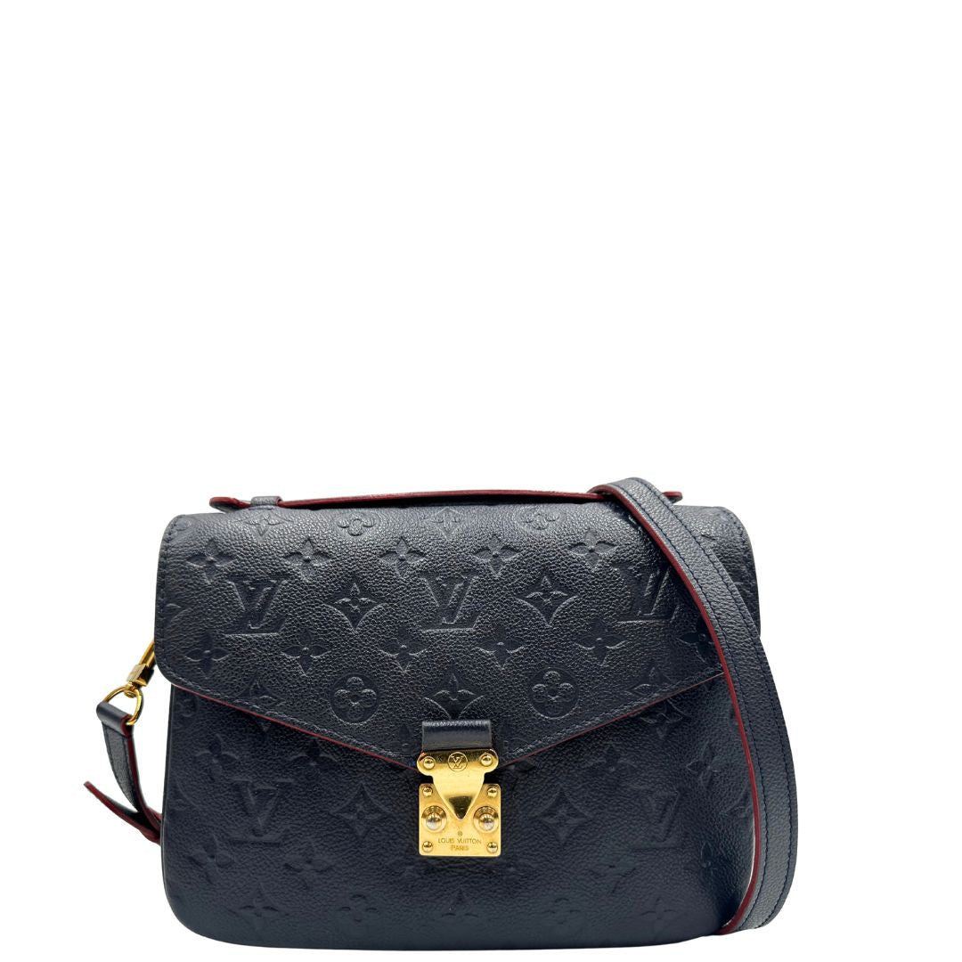 Front di una Borsa Louis Vuitton Métis in pelle monogram empreinte blu notte con parti metalliche dorate. Munita di un manico e tracolla regolabile con fibbia, e amovibile. Completa di corredo. Originale, usata, di lusso, in ottime condizioni.