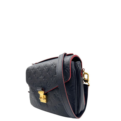 Lato sinistro di una Borsa Louis Vuitton Métis in pelle monogram empreinte blu notte con parti metalliche dorate. Munita di un manico e tracolla regolabile con fibbia, e amovibile. Completa di corredo. Originale, usata, di lusso, in ottime condizioni.