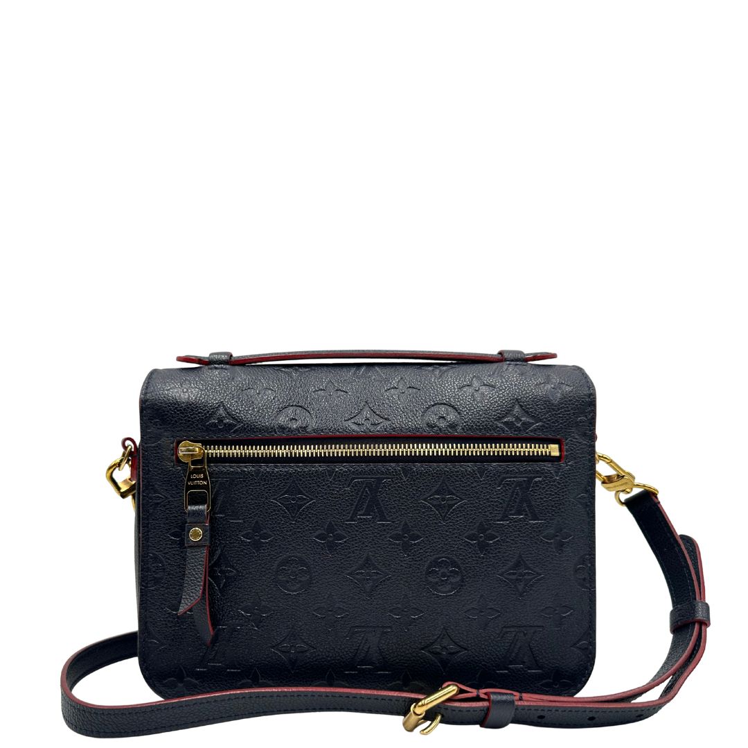 Retro di una Borsa Louis Vuitton Métis in pelle monogram empreinte blu notte con parti metalliche dorate. Munita di un manico e tracolla regolabile con fibbia, e amovibile. Completa di corredo. Originale, usata, di lusso, in ottime condizioni.