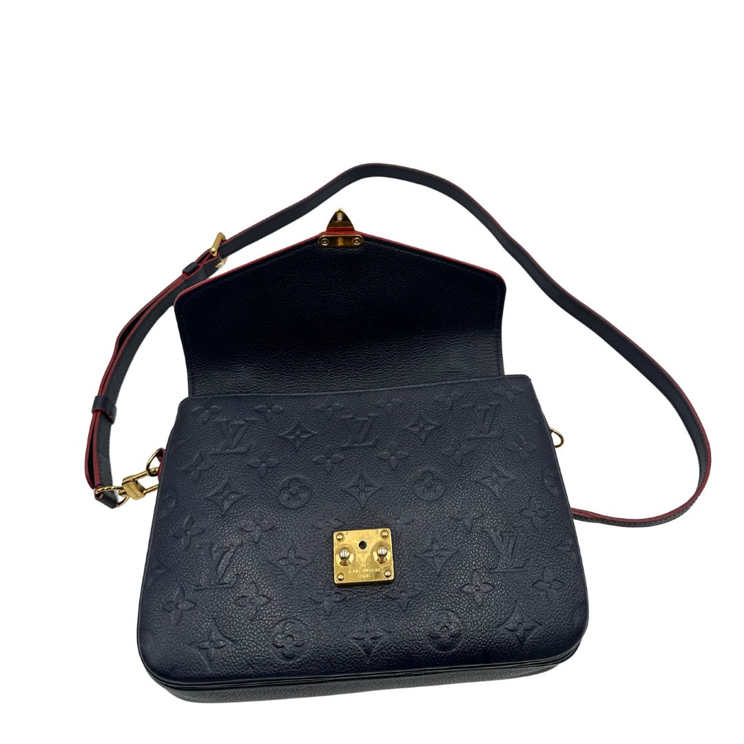 Interno di una Borsa Louis Vuitton Métis in pelle monogram empreinte blu notte con parti metalliche dorate. Munita di un manico e tracolla regolabile con fibbia, e amovibile. Completa di corredo. Originale, usata, di lusso, in ottime condizioni.