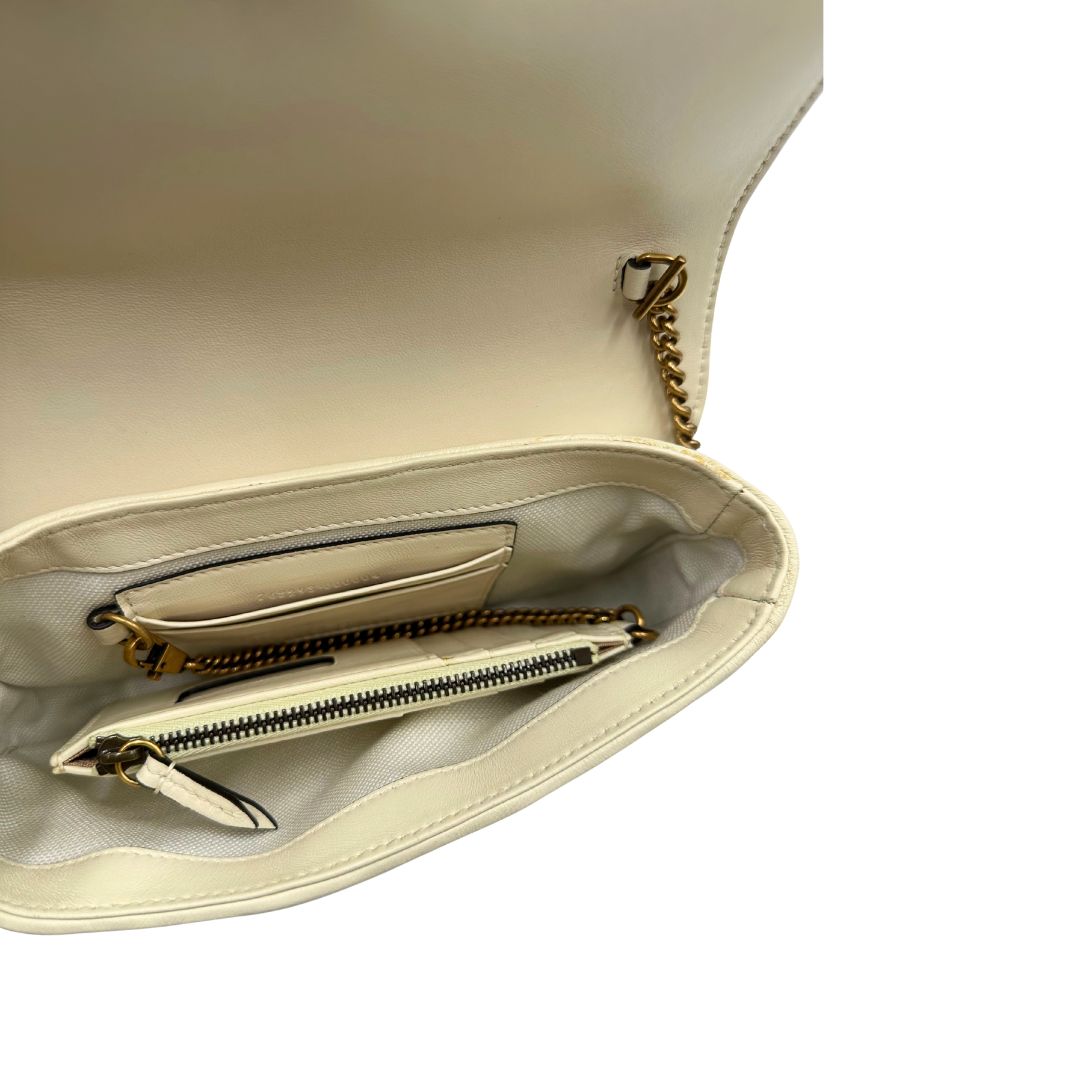 Interno di una Borsa Gucci GG Marmont in pelle matelassé color bianco latte, caratterizzata dalla classica trapuntatura a chevron e dagli iconici dettagli GG in metallo dorato anticato. Dotata di tracolla a catena amovibile. Presente un pouch portamonete con zip rimovibile. Completa di dustbag. Originale, usata, di lusso, in condizioni eccellenti.