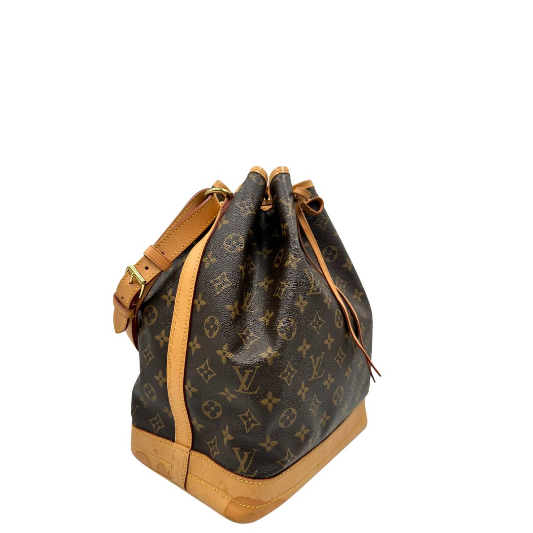 Lato destro di un Secchiello Noé Louis Vuitton in canvas marrone monogram con finiture in vacchetta naturale, tracolla regolabile con fibbia e parti metalliche dorate. Completo di dustbag. Originale, usato, di lusso, in ottime condizioni