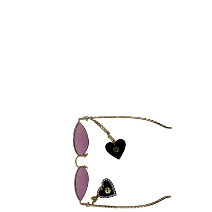 Occhiali da sole Gucci in metallo dorato e lenti rosa, muniti di due pendenti con cuore amovibili. Completi di sacchetto antipolvere, di lusso, originale, ottime condizioni. 