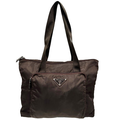 front Borsa Prada in nylon marrone scuro con parti metalliche argentate , munita di doppi manici in tessuto, indossabile a spalla. 