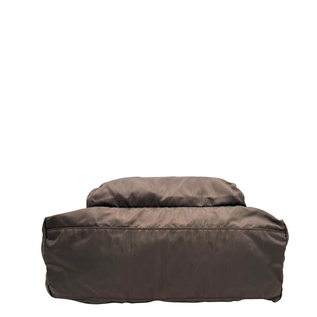 base Borsa Prada in nylon marrone scuro con parti metalliche argentate , munita di doppi manici in tessuto, indossabile a spalla. 