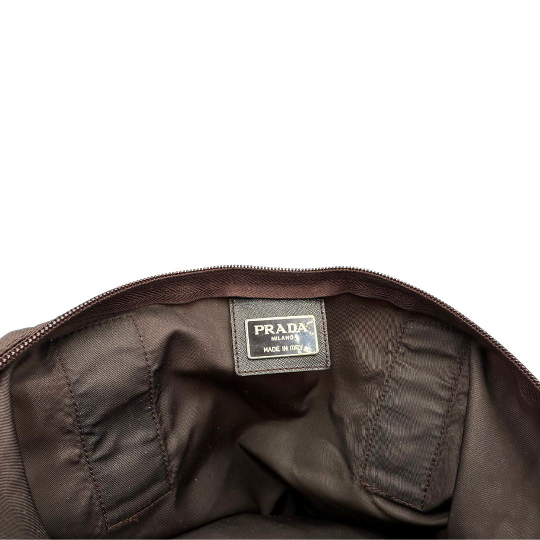 interno Borsa Prada in nylon marrone scuro con parti metalliche argentate , munita di doppi manici in tessuto, indossabile a spalla. 