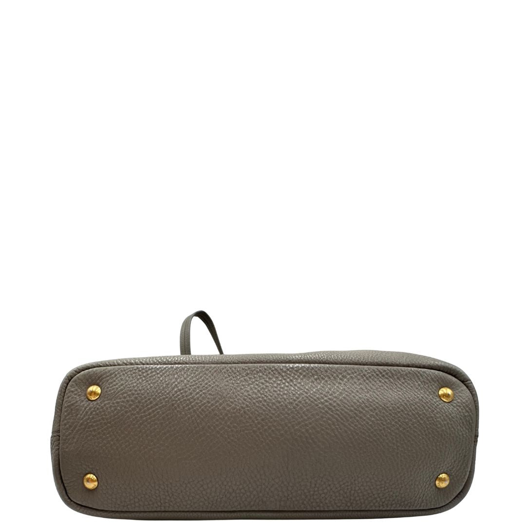 base Borsa Prada in pelle grigia martellata con parti metalliche dorate; munita di cerniere laterali e doppi manici, indossabile a spalla, di lusso, originale, ottime condizioni, usata. 