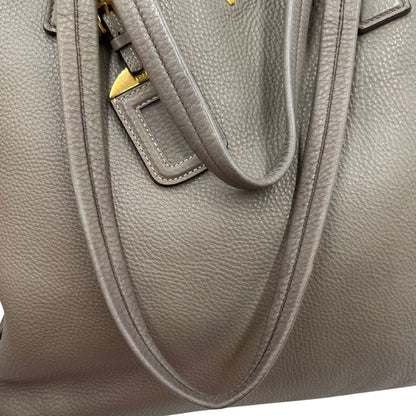 manici Borsa Prada in pelle grigia martellata con parti metalliche dorate; munita di cerniere laterali e doppi manici, indossabile a spalla, di lusso, originale, ottime condizioni, usata. 