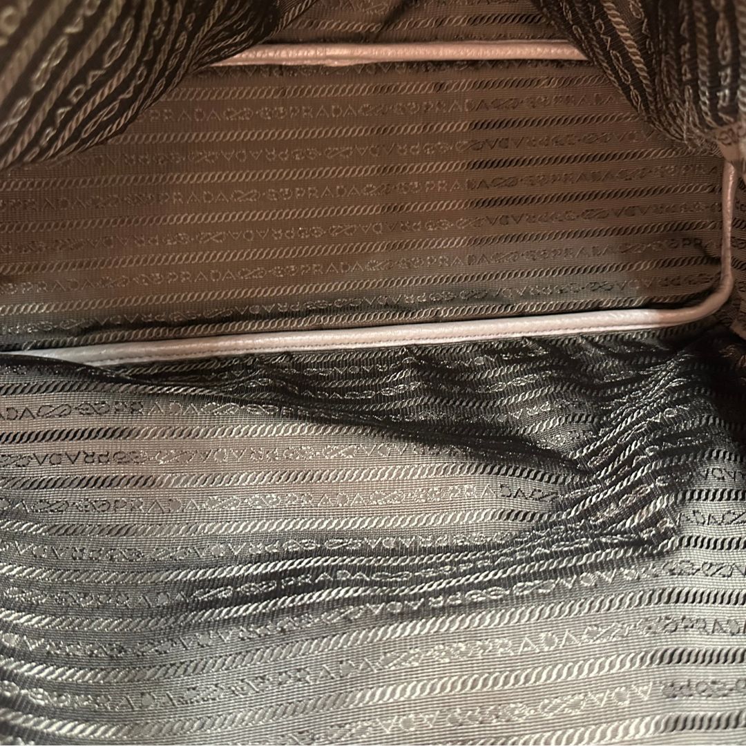 interno Borsa Prada in pelle grigia martellata con parti metalliche dorate; munita di cerniere laterali e doppi manici, indossabile a spalla, di lusso, originale, ottime condizioni, usata. 