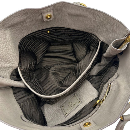 interno Borsa Prada in pelle grigia martellata con parti metalliche dorate; munita di cerniere laterali e doppi manici, indossabile a spalla, di lusso, originale, ottime condizioni, usata. 