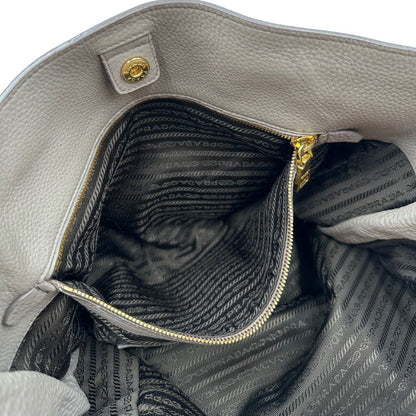 interno Borsa Prada in pelle grigia martellata con parti metalliche dorate; munita di cerniere laterali e doppi manici, indossabile a spalla, di lusso, originale, ottime condizioni, usata. 