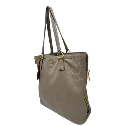 lato Borsa Prada in pelle grigia martellata con parti metalliche dorate; munita di cerniere laterali e doppi manici, indossabile a spalla, di lusso, originale, ottime condizioni, usata. 