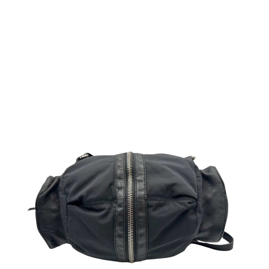 Base di uno zaino Alexander Wang in nylon nero e finiture in pelle tono su tono. Parti metalliche argentate; munito di doppie bretelle e una tracolla. Indossabile come zaino o a tracolla.