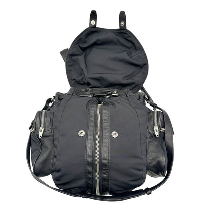 Apertura di uno zaino Alexander Wang in nylon nero e finiture in pelle tono su tono. Parti metalliche argentate; munito di doppie bretelle e una tracolla. Indossabile come zaino o a tracolla.