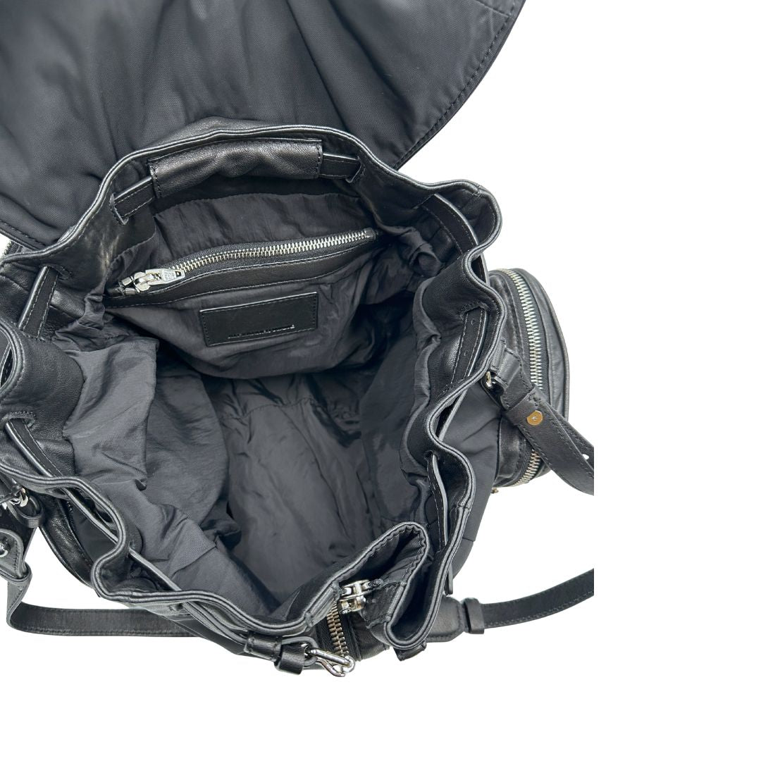 Interno di uno zaino Alexander Wang in nylon nero e finiture in pelle tono su tono. Parti metalliche argentate; munito di doppie bretelle e una tracolla. Indossabile come zaino o a tracolla.