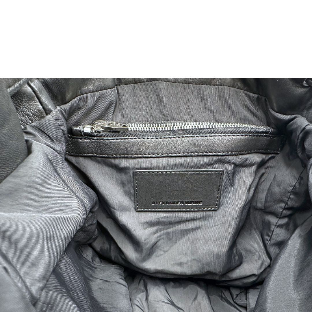 Interno di uno zaino Alexander Wang in nylon nero e finiture in pelle tono su tono. Parti metalliche argentate; munito di doppie bretelle e una tracolla. Indossabile come zaino o a tracolla.
