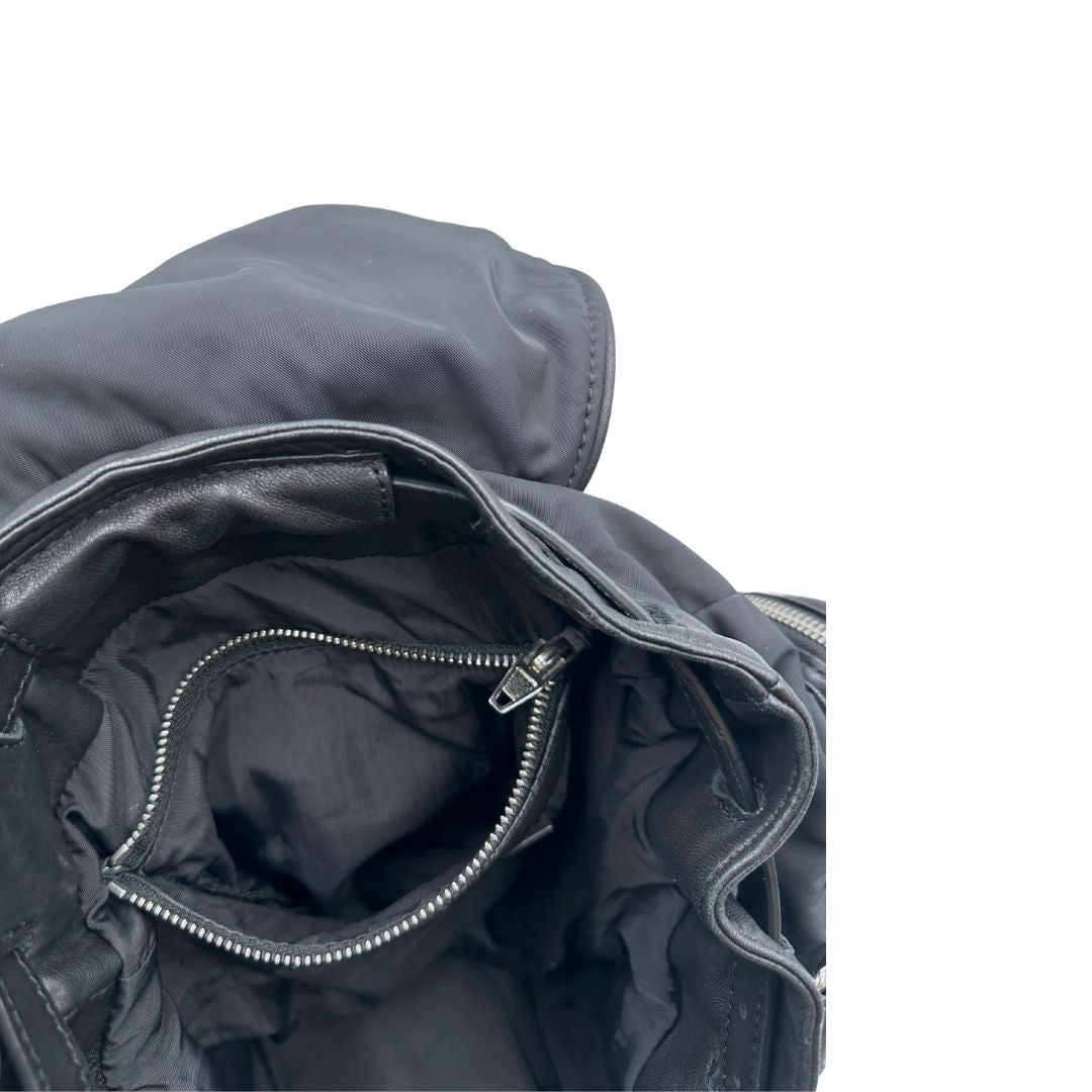 Interno di uno zaino Alexander Wang in nylon nero e finiture in pelle tono su tono. Parti metalliche argentate; munito di doppie bretelle e una tracolla. Indossabile come zaino o a tracolla.