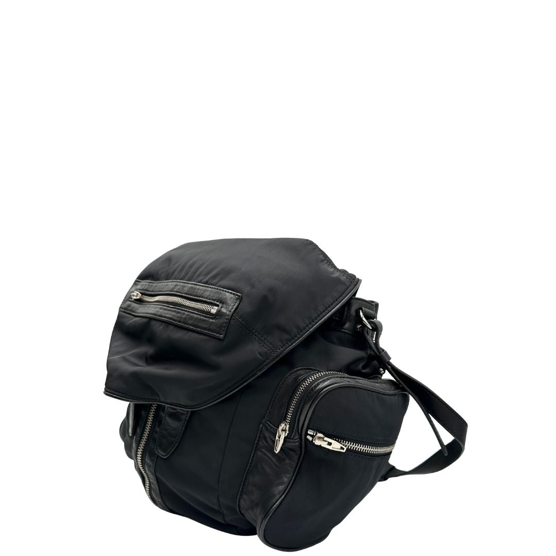 Laterale destro di uno zaino Alexander Wang in nylon nero e finiture in pelle tono su tono. Parti metalliche argentate; munito di doppie bretelle e una tracolla. Indossabile come zaino o a tracolla.