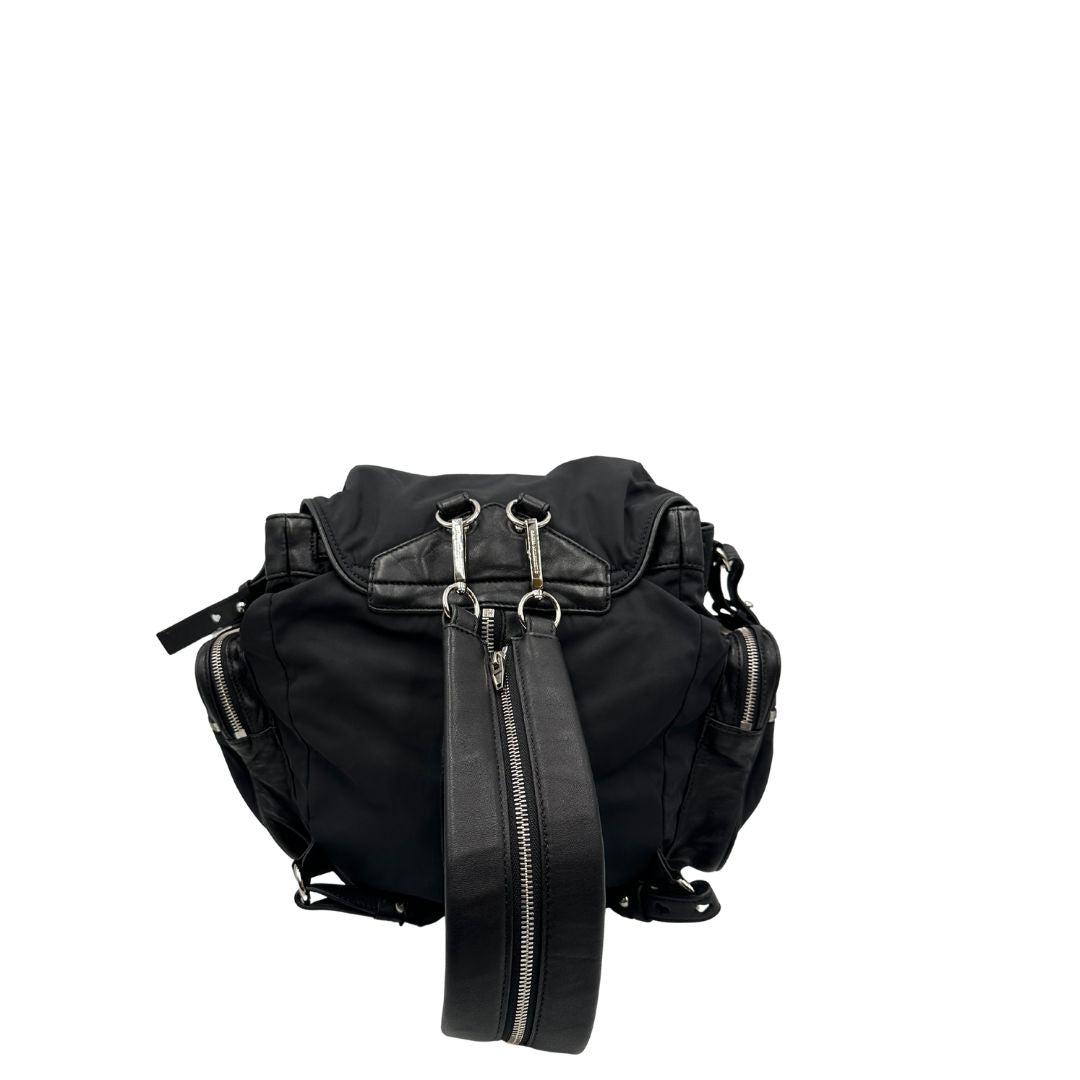 Vista superiore di uno zaino Alexander Wang in nylon nero e finiture in pelle tono su tono. Parti metalliche argentate; munito di doppie bretelle e una tracolla. Indossabile come zaino o a tracolla.