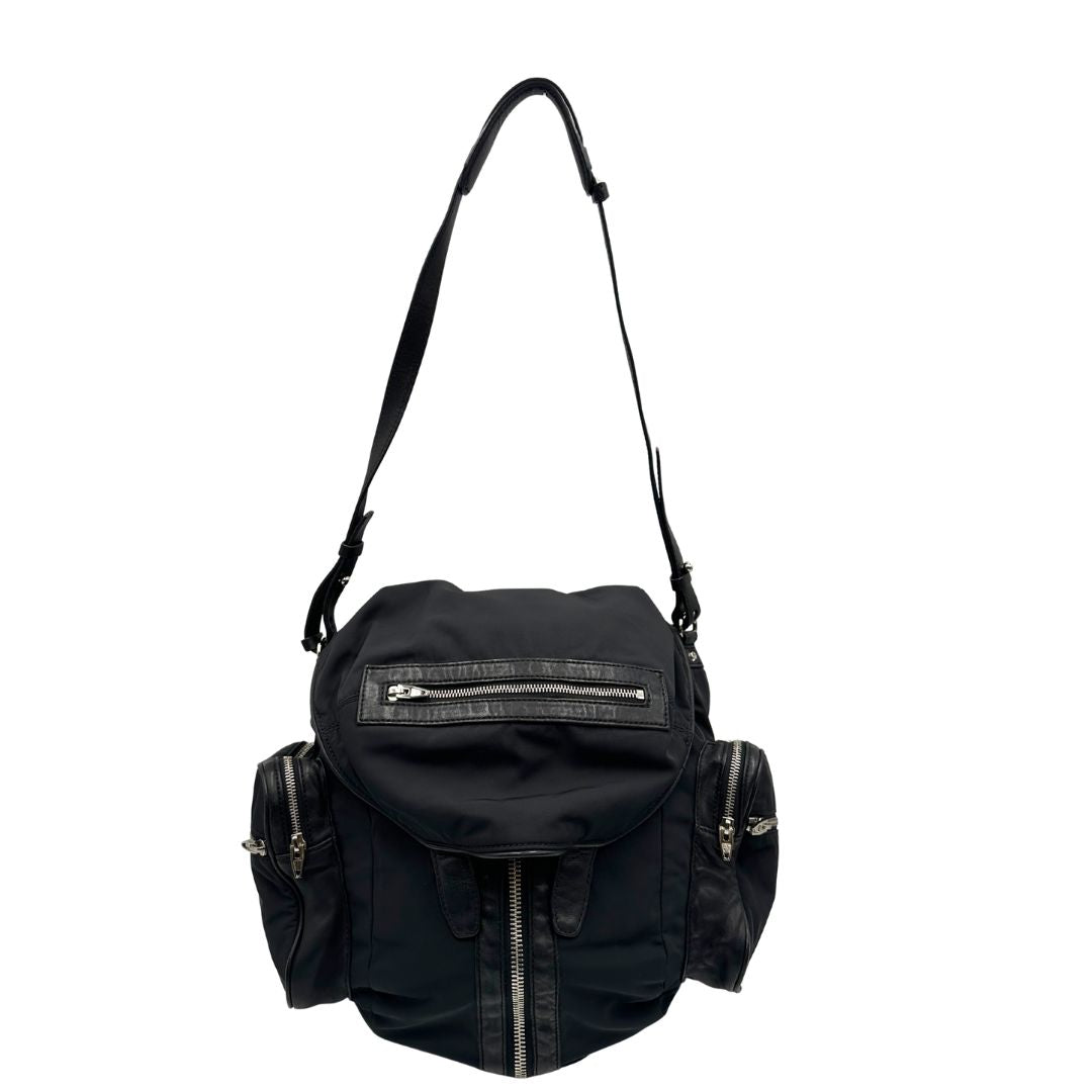 Front di uno zaino Alexander Wang in nylon nero e finiture in pelle tono su tono. Parti metalliche argentate; munito di doppie bretelle e una tracolla. Indossabile come zaino o a tracolla.