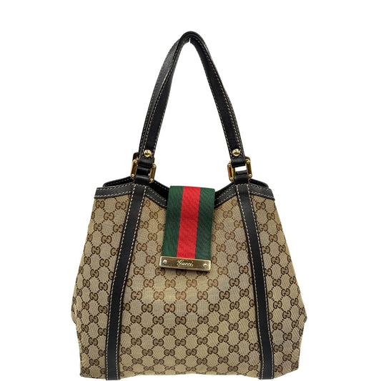 front Borsa Gucci in tessuto GG beige con finiture in pelle marroni, impreziosita da da striscia Web sulla chiusura verde e rossa e parti metalliche dorate; munita di doppi manici, da portare a spalla, di lusso, originale, usata. 